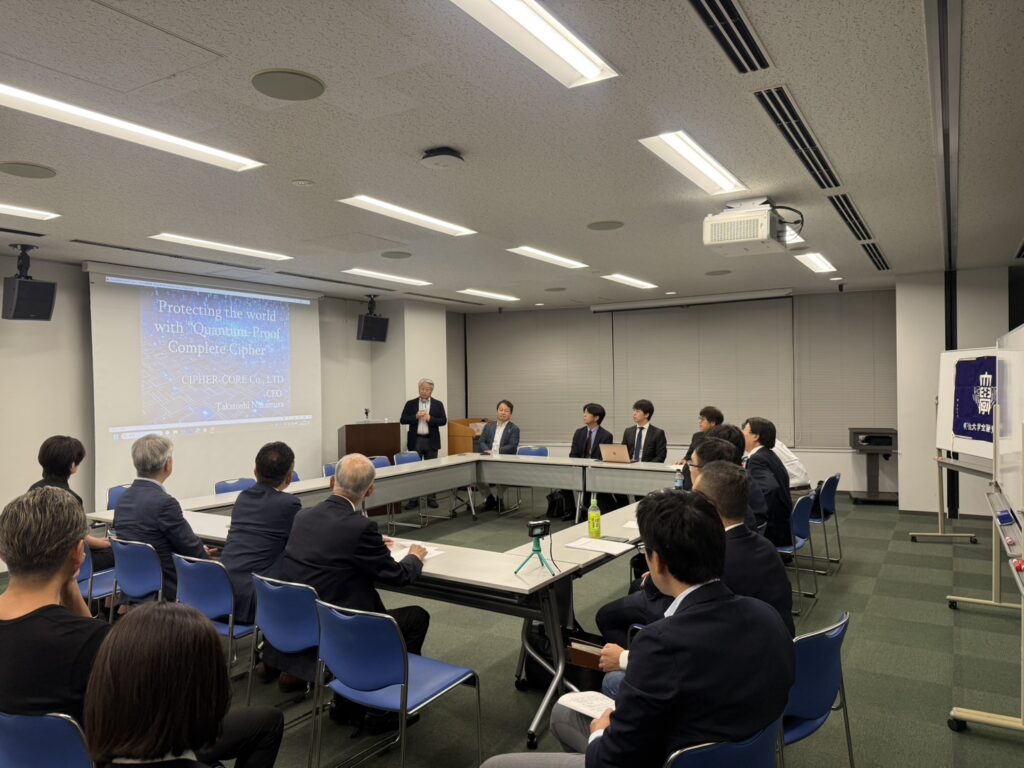 明治大学金融紫紺会 定例セミナーにて、サイファ・コア代表取締役CEO 中村宇利が「Protecting the world with Quantum-Proof Complete Cipher」と題したスライドを投影しながら登壇している様子。会場には金融・学術分野の参加者が着席している。